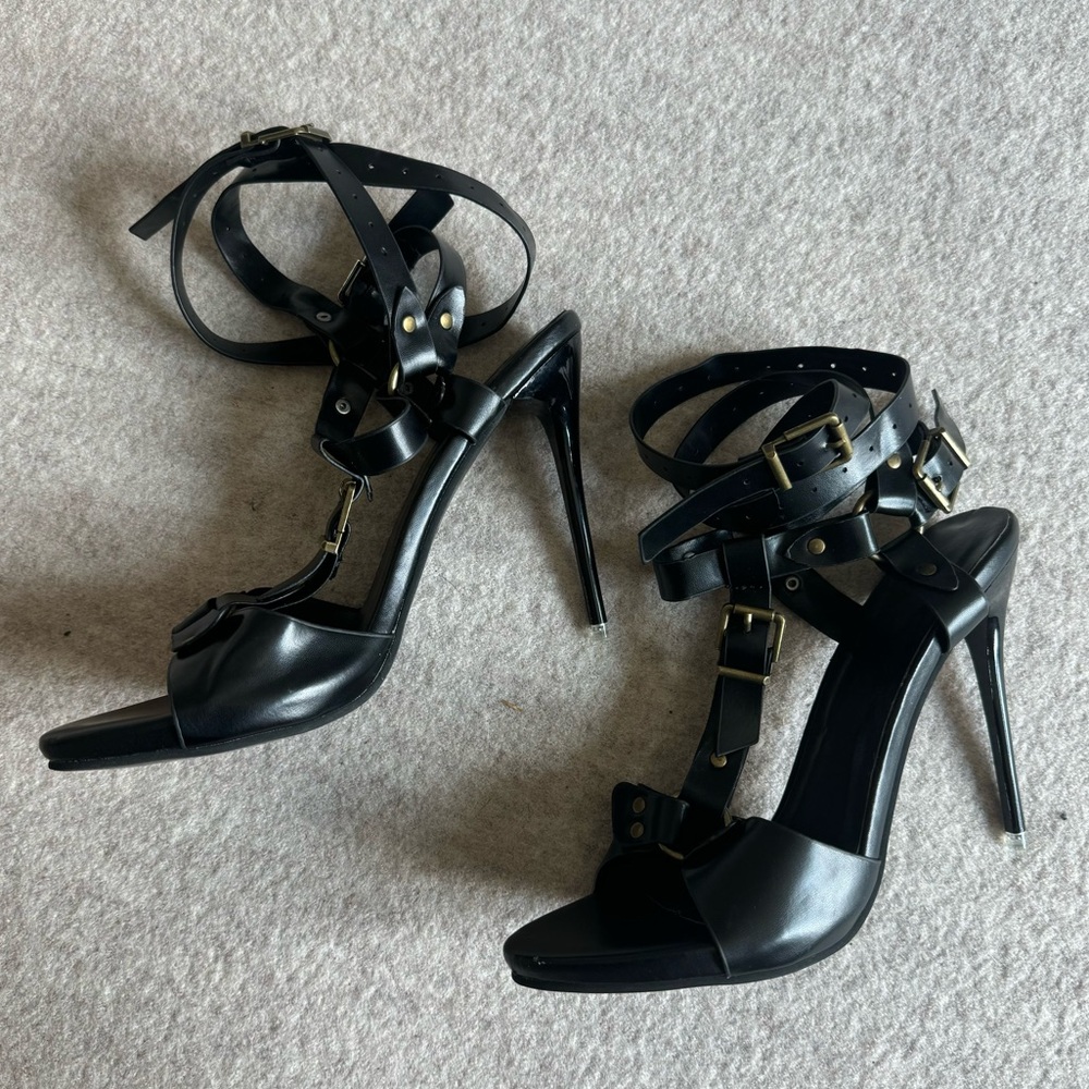 Black leather strapped high heels with gold hardware buckles